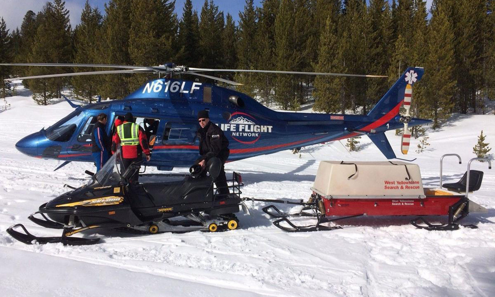 Helicopter rescuing snowmobiler